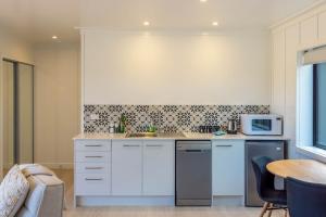 a kitchen with a sink and a microwave at Onetangi Beach Stays Studio 2 - Coast & Country in Onetangi