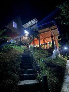 una rampa di scale che porta a un edificio di notte di Forest Camp El Nido a El Nido