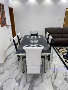 une salle à manger avec une table noire et des chaises blanches dans l'établissement Villas meublé yoff, à Dakar