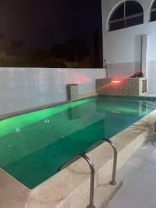 達喀爾的住宿－Villas meublé yoff，夜间在房子里的一个游泳池