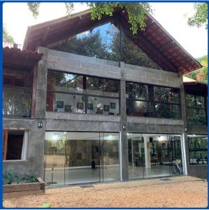 eine Außenansicht eines Gebäudes mit Glastüren in der Unterkunft Casa da Floresta in Lavras