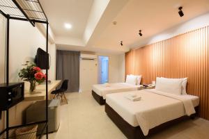 a hotel room with two beds and a television at Grand Watergate Hotel in Bangkok
