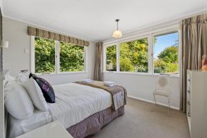 um quarto com uma cama e duas janelas em Tui Paradise - Havelock North em Havelock North