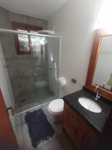 ein Bad mit einer Dusche, einem WC und einem Waschbecken in der Unterkunft Casa da Floresta in Lavras