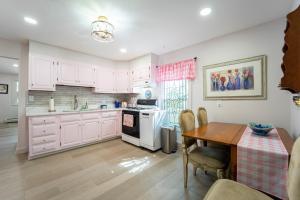 una cucina con armadi bianchi e tavolo in legno di Grandma's Summer House Beverly Beach a Edgewater