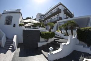 a building with stairs and trees in front of it at Hotel Cala Moresca in Bacoli