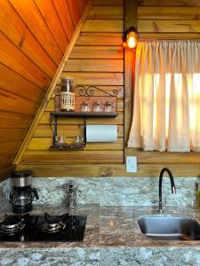 - une cuisine avec une cuisinière et un évier dans la chambre dans l'établissement Refúgio Suiço em Vargem Alta, à Vargem Alta