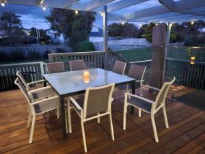 - une table et des chaises sur une terrasse la nuit dans l'établissement Fifteen Mercury, à Venus Bay