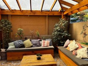 un patio con 2 divani e un tavolo con cuscini di Casa amoblada en Nos a Santiago