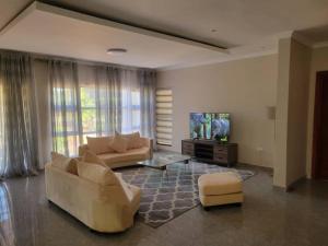 a living room with two couches and a flat screen tv at Sable Suites B2, 2 & 3 Bed Apartments in Kabulonga in Lusaka