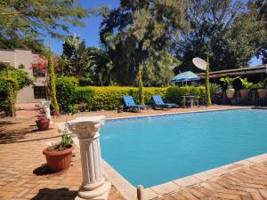 a large swimming pool with a statue next to it at Sable Suites B2, 2 & 3 Bed Apartments in Kabulonga in Lusaka