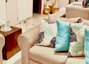 a living room with a couch with pillows on it at Casa de las Palmas tu destino en Morelos in Alpuyeca