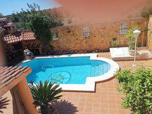 a swimming pool in the middle of a yard at chalet, villa rodeada de naturaleza con piscina cerca de la ciudad in Valencia