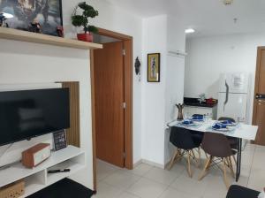 uma sala de estar com uma cozinha com uma mesa e uma televisão em Lindo apart. estrutura de hotel em Brasília