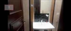 a bathroom with a sink and a mirror at شقة فندقية في فندق هيلتون المعادي علي الكورنيش مباشرة in Cairo
