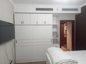 a bedroom with white cabinets and a white bed at شقة فندقية في فندق هيلتون المعادي علي الكورنيش مباشرة in Cairo
