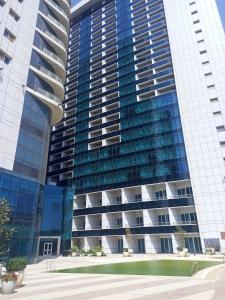 un gran edificio de cristal con un parque delante de él en شقة فندقية في فندق هيلتون المعادي علي الكورنيش مباشرة 5, en El Cairo
