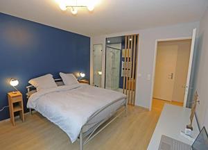 una camera con un grande letto con una parete blu di Appartement 5 pcs pour JO 2024 a Saint-Denis