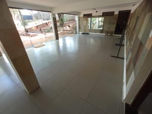 ein leeres Zimmer mit einem großen weißen Fliesenboden in der Unterkunft Casa da Floresta in Lavras