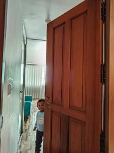 Renta de una habitación para 2 personas في ليما: طفل صغير واقف امام باب