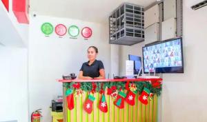 a woman standing behind a counter with christmas decorations at iPark Hotel by Hiverooms in Cebu City