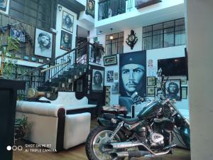 een motorfiets geparkeerd in een kamer met foto's aan de muur bij Hotel el Che No apto para corruptos in Azogues