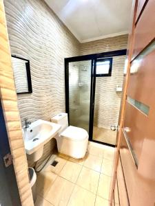 a bathroom with a toilet and a sink and a shower at Sierra Pines Place Tagaytay in Tagaytay