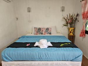 a bed with a stuffed animal sitting on it at Thai Garden​ Resort​ Kanchanaburi​ in Kanchanaburi