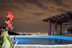 una piscina con vistas a la ciudad por la noche en Habitacion The View, en Cali