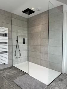 a shower with a glass door in a bathroom at Maison bretonne en pierre rénovée in Plédran +13 photos