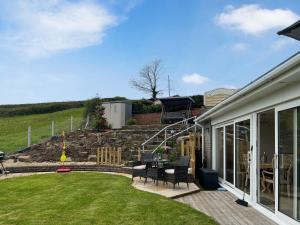 a patio with a table and chairs in a yard at Estuary Retreat in Llanelli