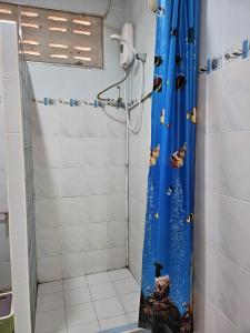 a bathroom with a shower with a blue shower curtain at Thai Garden​ Resort​ Kanchanaburi​ in Kanchanaburi