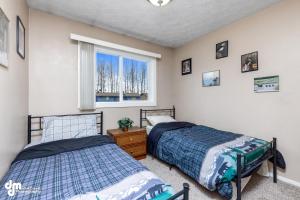 1 dormitorio con 2 camas y ventana en Alaska Villa - Papa Murph - fits 11 !, en Anchorage