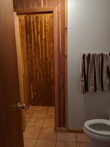 a bathroom with a toilet and an open door at Beautiful quiet getaway in dark skies community. Perfect for a relaxing stay in the mountains in Westcliffe +16 photos