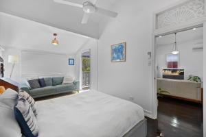 Bli Bliにある"Xanadu" Charming 2-Bed Retreat by Marcoola Beachの白いベッドルーム(ベッド1台、ソファ付)