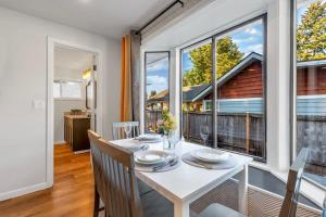une salle à manger avec une table blanche, des chaises et des fenêtres dans l'établissement Hidden Renovated Garden Cottage Near Costco I99, à Shoreline 24 autres photos