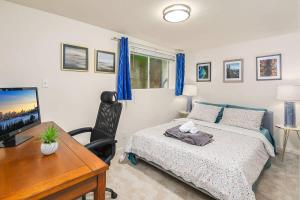 a bedroom with a bed and a desk with a computer at Cozy Getaway Yard House with BBQ - UW - Children Hospital in Seattle