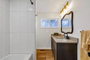 a bathroom with a shower and a sink and a mirror at Hidden Renovated Garden Cottage Near Costco I99 in Shoreline