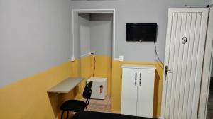 a room with a bench and a tv on a wall at Pousada uberaba in Uberaba