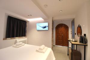 a bedroom with a bed and a tv on the wall at Melina's Seaside Retreat in Ksamil