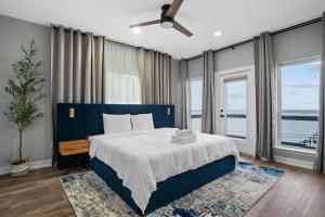 a bedroom with a blue bed with a view of the ocean at Waterfront Home with Views - Hot Tub & Movie Theatre in Bacliff