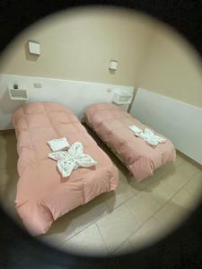 two beds sitting next to each other in a room at El viejo bar hotel in Perito Moreno