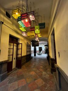 un pasillo con luces coloridas colgando de un edificio en Casa Veeyuu, en Puebla