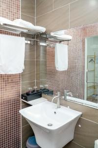 a bathroom with a white sink and a mirror at Palas House in Ho Chi Minh City