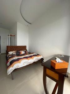 Dormitorio pequeño con cama y mesa en d’Viella Lampung, en Kedaton