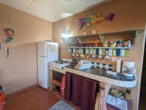 a kitchen with a refrigerator and a counter top at Villa Cascada de Flores in Chacala +1 photo