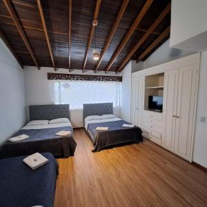 a room with two beds and a television in it at Fortaleza Diosa Chia in Chía