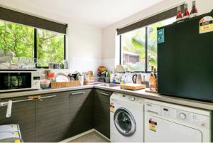 a kitchen with a washing machine and a window at Bayside Boutique Retreat- Black Rock, Melbourne. in Black Rock North