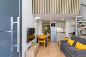 a living room and kitchen with a couch and a table at Nice new duplex in front of Palacio VistaAlegre in Madrid