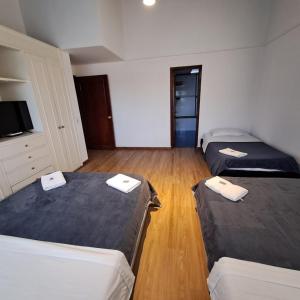 a room with two beds and a flat screen tv at Fortaleza Diosa Chia in Chía